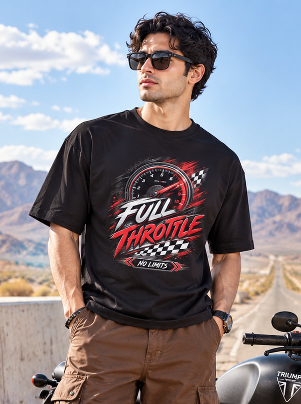 Male model wearing Zingleberry Full Throttle black oversized biker graphic T-shirt with brown cargo pants beside a motorcycle on a desert highway.