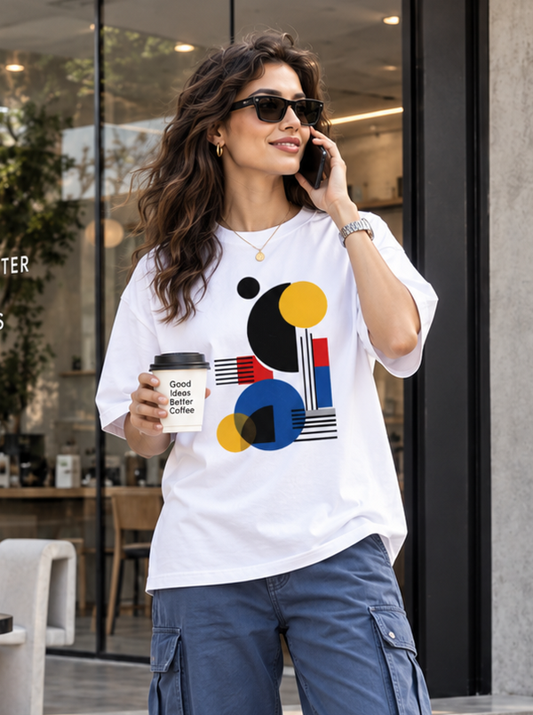 Woman wearing Zingleberry Geometric Rhythm white oversized T-shirt with blue cargo pants and white sneakers.