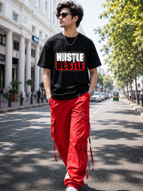 Male model wearing Zingleberry Hustle Bustle Premium Black Cotton Graphic T-Shirt paired with red cargo pants for a bold urban streetwear look