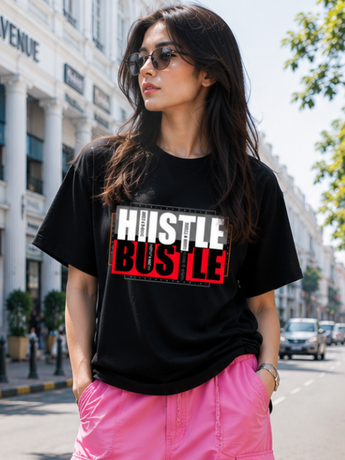 Female model wearing Zingleberry Hustle Bustle Premium Unisex Black Cotton Graphic T-Shirt styled with pink cargo pants for a trendy summer streetwear outfit.