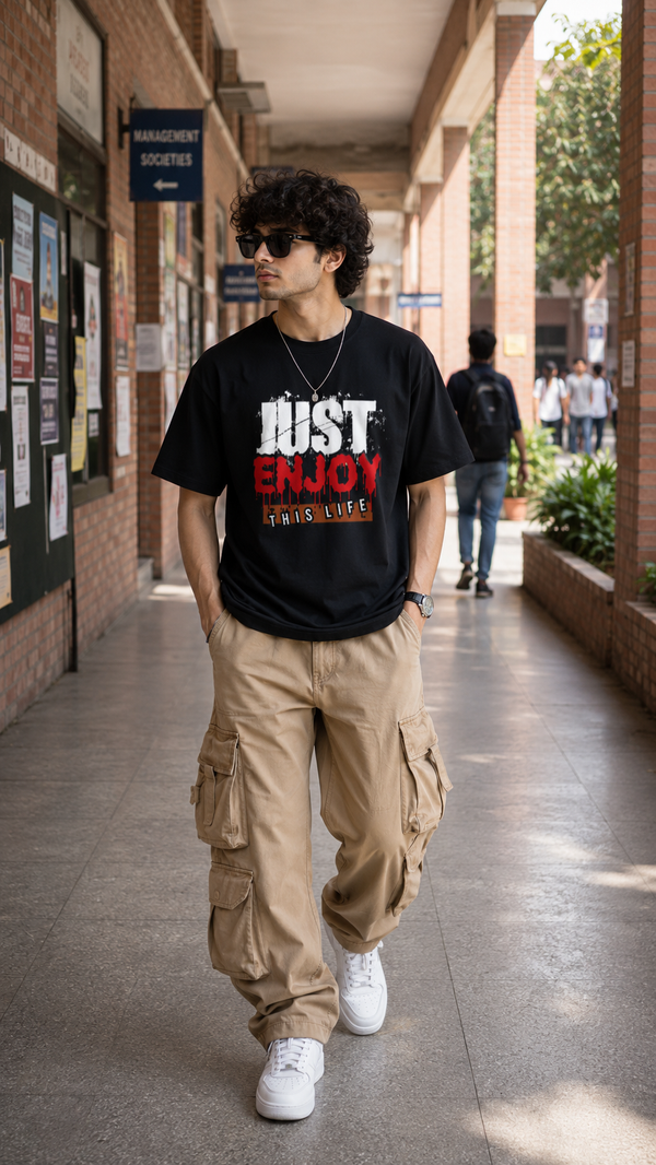 Male model wearing Zingleberry Just Enjoy This Life Premium Black Cotton Graphic T-Shirt paired with beige cargo pants for a modern casual streetwear look.