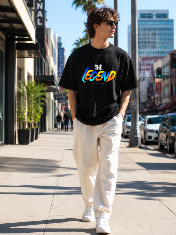 Male model wearing Zingleberry Premium Unisex Classic Crew The Legend black graphic T-shirt with white trousers in a premium urban streetwear photoshoot.