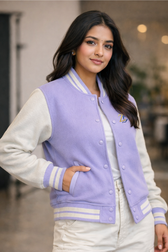 Close-up of a woman wearing the Zingleberry premium lilac varsity jacket with cream sleeves, showing the ribbed cuffs and high-quality fabric detail.