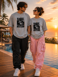 Two people standing by a pool with a sunset in the background, wearing zingleberry's unisex oversized tshirt