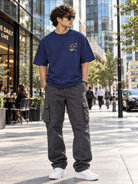 Male model wearing Zingleberry Another Dimension navy blue oversized T-shirt with charcoal cargo trousers