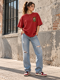 Woman wearing Zingleberry Become Who You Are red oversized graphic T-shirt with baggy blue jeans and sneakers.