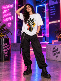 Woman wearing Zingleberry Botanical Abstract Art white oversized T-shirt with black cargo pants and chunky boots.