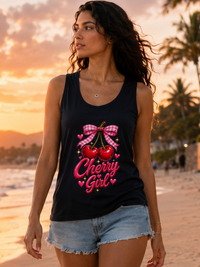 Female model wearing Zingleberry Cherry Girl graphic tank top with denim shorts during a sunset beach walk.