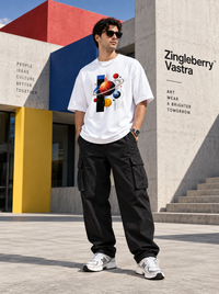 Male model wearing Zingleberry white Cosmic Orbit oversized graphic T-shirt with black cargo pants and sneakers.