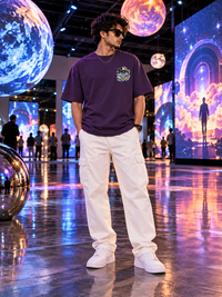 Male model wearing Zingleberry purple unisex oversized T-shirt with cosmic eye left-chest graphic and white cargo pants.
