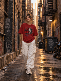 Female model wearing Zingleberry red oversized cotton T-shirt featuring Crown Skull and Roses gothic graphic with white cargo pants.