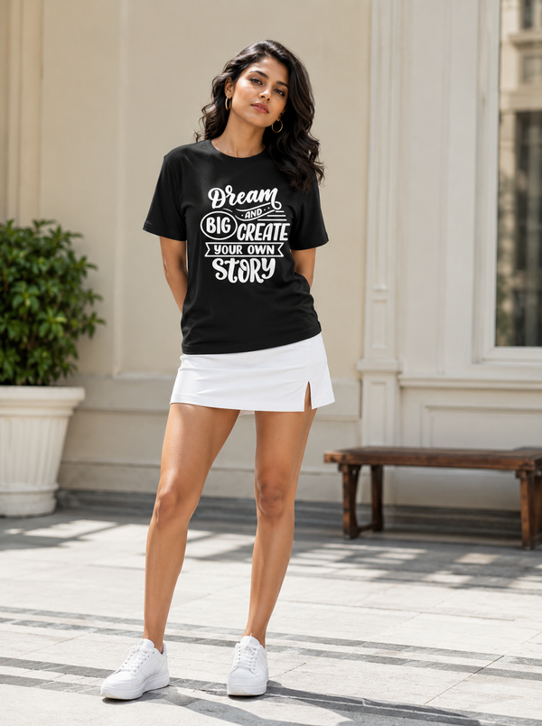 Female model wearing Zingleberry Dream Big Create Your Own Story black unisex cotton graphic T-shirt styled with a white skirt.