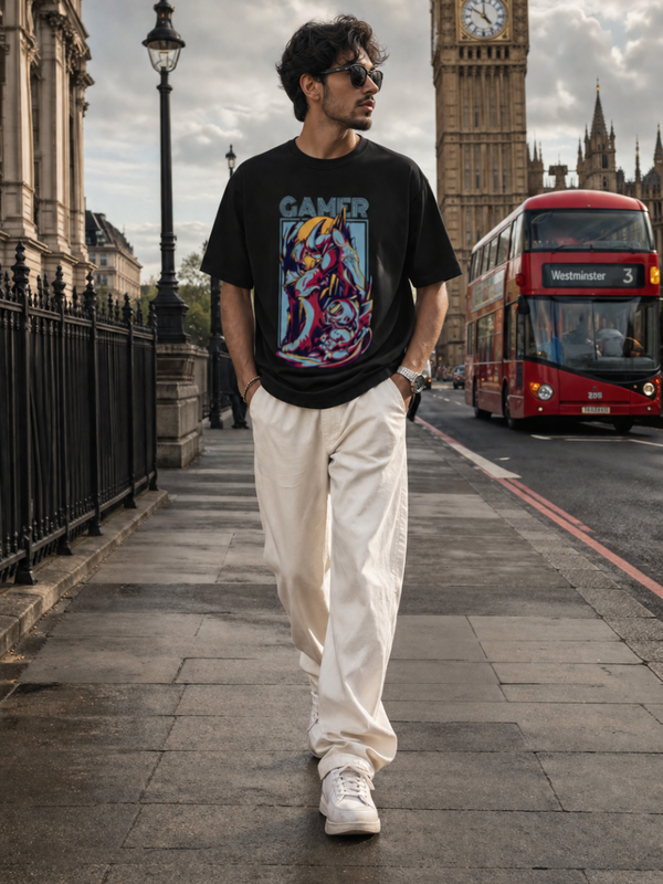 Male model wearing Zingleberry Gamer Premium Black Cotton Graphic T-Shirt with futuristic gaming artwork, paired with white trousers for casual urban streetwear fashion in London.