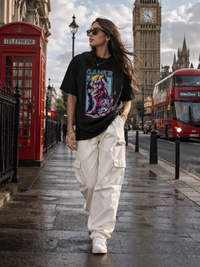 Female model wearing Zingleberry Gamer Premium Unisex Black Cotton T-Shirt featuring a vibrant gaming graphic print, styled with white cargo pants for modern summer streetwear in London.