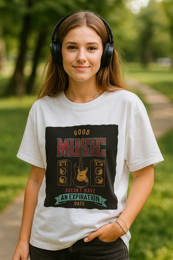 Young woman in Zingleberry’s oversized unisex white t-shirt featuring retro guitar and speaker print with 'Good Music Doesn’t Have an Expiration Date' quote, enjoying music in the park.