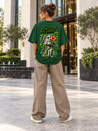 Woman wearing Zingleberry Grow Through It bottle green oversized T-shirt with botanical sculpture and hibiscus statement back print
