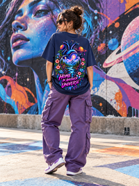 Female model wearing Zingleberry Home in Another Universe navy blue oversized T-shirt featuring colourful galaxy, mountain and floral heart artwork with lavender cargo trousers