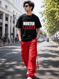 Male model wearing Zingleberry Hustle Bustle Premium Black Cotton Graphic T-Shirt paired with red cargo pants for a bold urban streetwear look