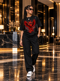 Female model wearing Zingleberry Inferno Rebirth black oversized phoenix T-shirt with black trousers