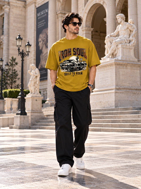 Male model wearing Zingleberry Iron Soul mustard oversized T-shirt with black cargo trousers and white sneakers.