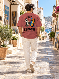Man wearing Zingleberry Keep Becoming unisex oversized T-shirt with geometric butterfly graphic back print.