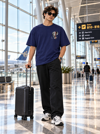 Male model wearing Zingleberry Lost in Thought navy blue unisex oversized T-shirt with artistic left chest graphic.