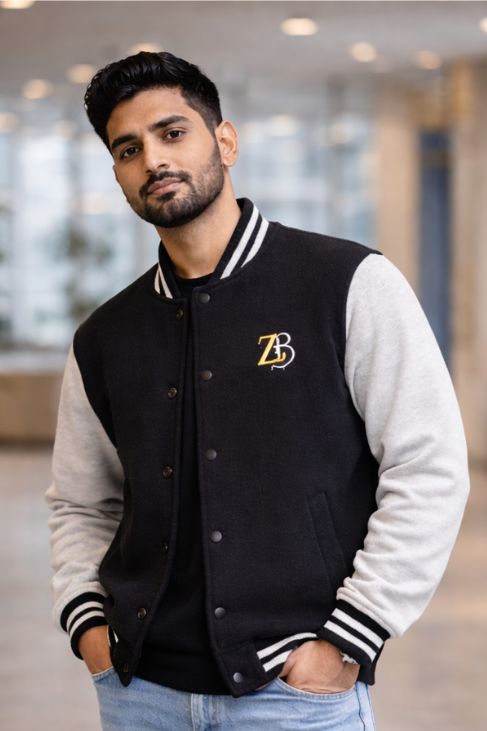 A man wearing the Zingleberry black and off-white unisex varsity jacket with light-wash denim jeans, showcasing a clean and casual aesthetic.