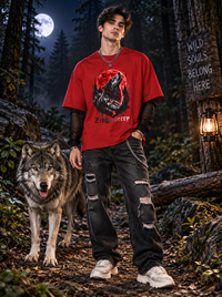 Male model wearing Zingleberry Moon Wolf red oversized cotton T-shirt with black distressed jeans in moonlit forest.