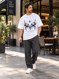 Male model wearing Zingleberry Nexus white unisex oversized T-shirt with charcoal relaxed trousers and white sneakers.