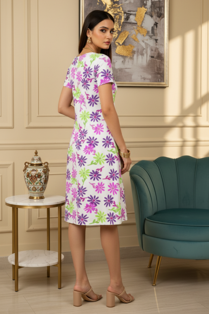 Woman in a Zingleberry Premium A-Line Dress highlighting flattering A-line silhouette and soft fabric dress standing in a stylish room with a teal chair and decorative items.