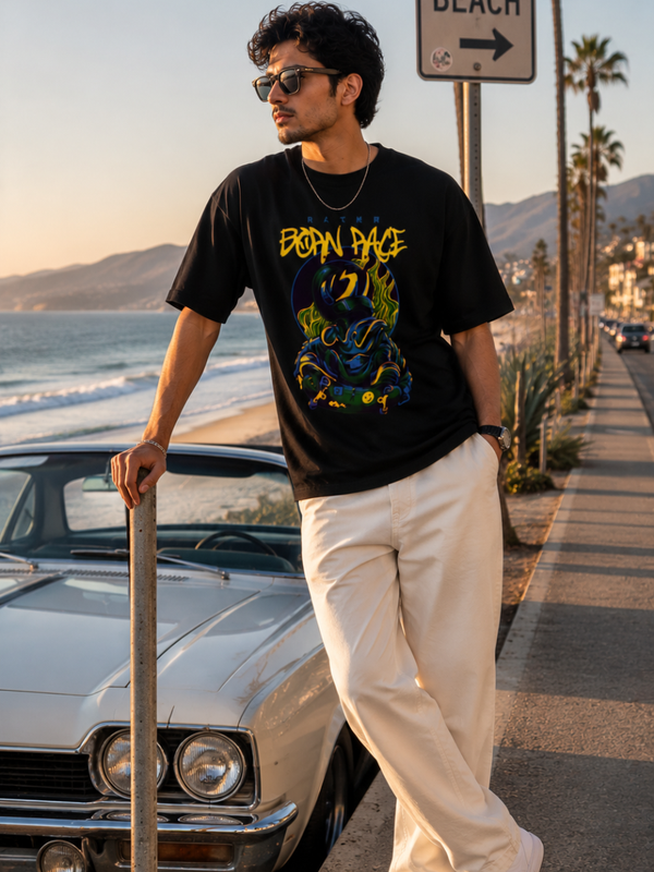 Male model wearing Zingleberry Premium Unisex Classic Crew Born Rage black graphic T-shirt with white trousers in a premium coastal streetwear photoshoot.