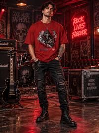 Male model wearing Zingleberry Reaper Rock red oversized graphic T-shirt with distressed black jeans and combat boots in rock music studio.