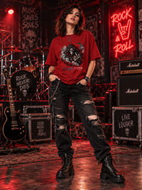 Female model wearing Zingleberry Reaper Rock red oversized cotton T-shirt with distressed black jeans and combat boots in rock music setting.