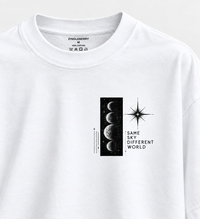 Zingleberry white unisex oversized T-shirt with 3 x 3 inch Same Sky Different World celestial left chest print.