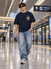 Man wearing Zingleberry Trust Your Timing navy blue oversized T-shirt with celestial clock left-chest graphic.