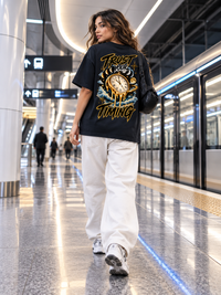Woman wearing Zingleberry Trust Your Timing navy blue oversized graphic T-shirt with celestial statement back artwork.