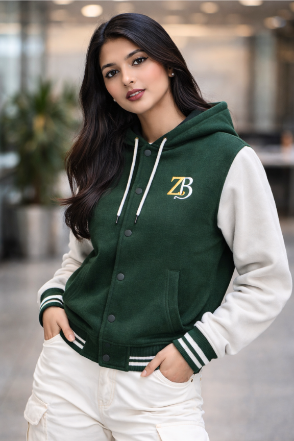 A woman modeling the Zingleberry Bottle green and off-white premium varsity hoodie jacket, styled with white cargo pants for an urban look.