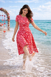 Zingleberry Vastra red A-line midi dress with white heart print, short sleeves, and round neck, worn by a woman on a beach.