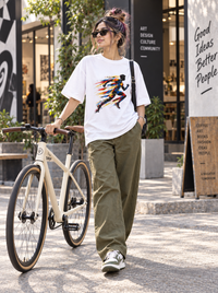 Woman wearing Zingleberry Velocity Runner Abstract Art white oversized T-shirt with olive wide-leg trousers and sneakers.