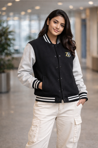 A woman modeling the Zingleberry black varsity jacket with off-white sleeves, paired with white cargo pants for a modern urban fashion look.