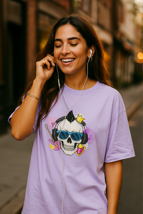 Smiling woman in Zingleberry's purple oversized unisex t-shirt with funky skull headphone print, listening to music with earphones in a casual urban street style.